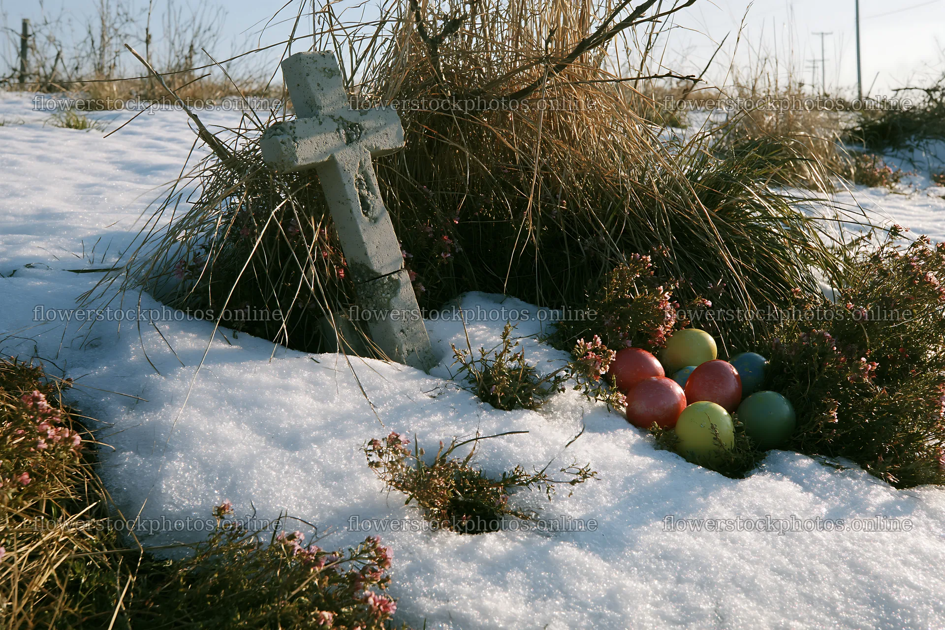Stone Christian cross in snowy meadow with colorful eggs – flower stock photos 9722x6480